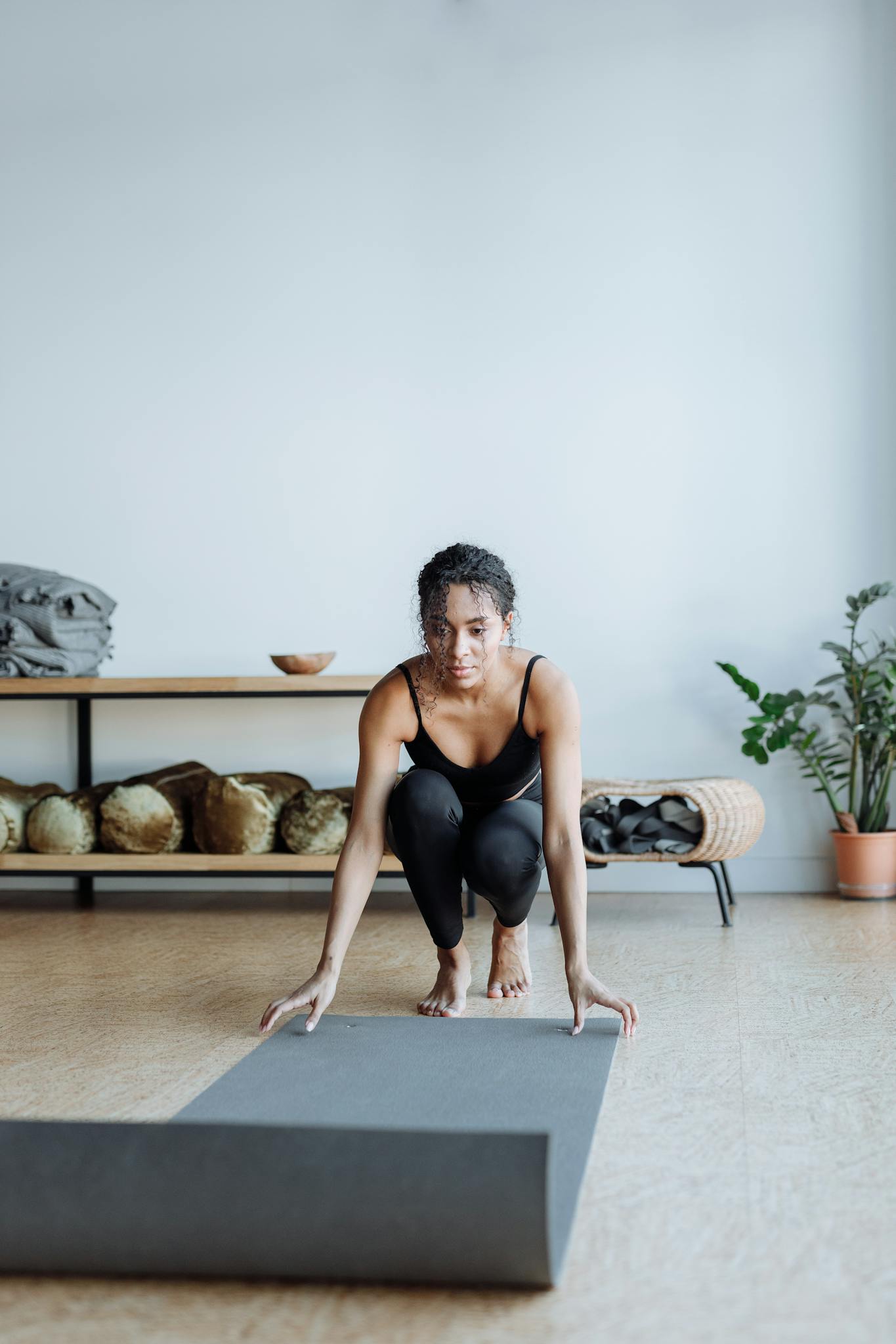 A young woman preparing for yoga in a serene studio, embodying mindfulness and fitness.